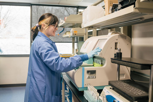 A woman works with lab testing equipment