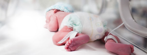A newborn sleeping in a hospital bed