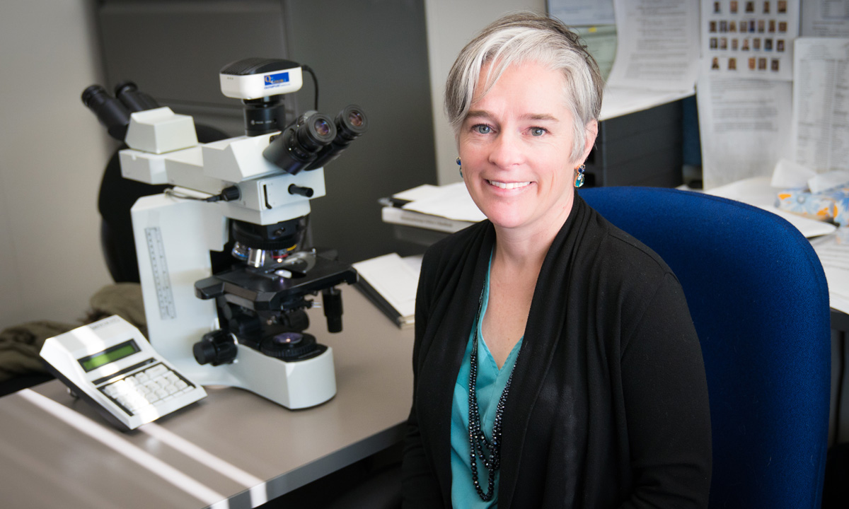 ARUP Medical Director Kristin Hunt Karner sits at a desk in a laboratory.