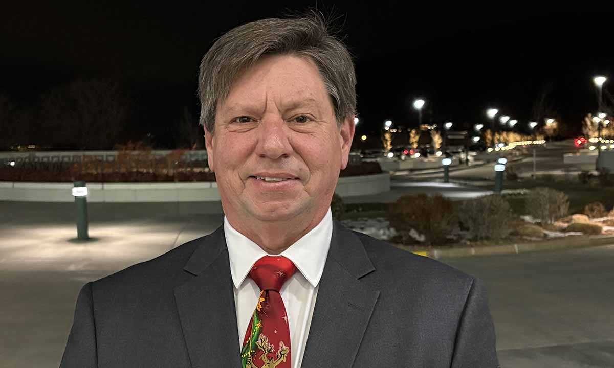 Eric Allen stands outside in front of distant streetlights.